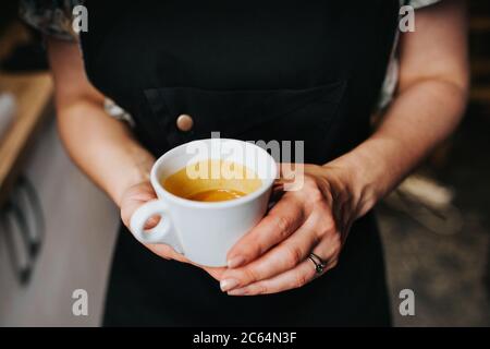 Eine Tasse Espresso in den Händen einer Barista Frau - Guten Morgen Stockfoto