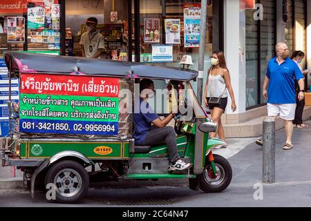 Tuk Tuk Fahrer trägt Gesichtsmaske wartet auf Kunden während covid 19 Pandemie, Bangkok, Thailand Stockfoto