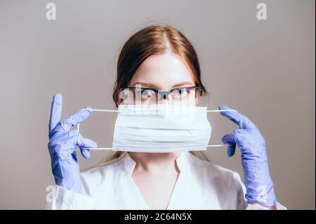 Ärztin in einem weißen Mantel mit Gesichtsmaske oder medizinische Maske zum Schutz vor Coronavirus Stockfoto