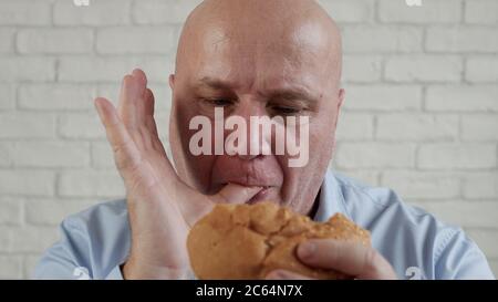 Hungerte Person essen einen leckeren Hamburger, genießen Sie einen köstlichen Snack in einem Fast Food Stockfoto