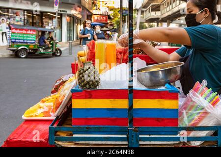 Straßenverkäufer mit Gesichtsmaske Verkauf Obst und Saft nehmen während covid 19 Pandemie, Bangkok, Thailand Stockfoto