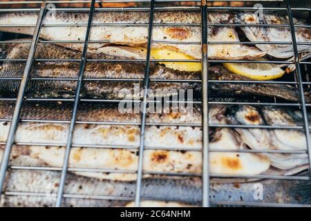 Gegrillter Seebarsch im Grill - knusprig duftende Kruste auf Fisch - kein fettiges schmackhaftes Gericht Stockfoto