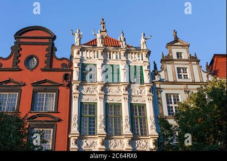 Dekorative Fassade des Goldenen Hauses, Dlugi Targ (Long Market Street). Blick auf die Dachlinie mit Statuen geschmückt, die die vier Kardinaltugenden darstellen Stockfoto