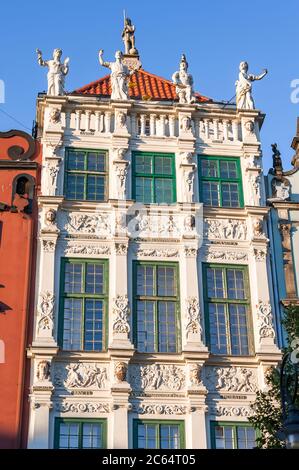 Dekorative Fassade des Goldenen Hauses, Dlugi Targ (Long Market Street). Blick auf die Dachlinie mit Statuen geschmückt, die die vier Kardinaltugenden darstellen Stockfoto