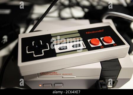 Retro-Gaming. 8-Bit Nintendo Game Controller mit bunten Knöpfen und Mini NES (Nintendo Entertainment System) für modernes Publikum wiederveröffentlicht Stockfoto