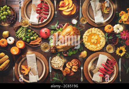 Thanksgiving Feier traditionelles Abendessen. Gebratener truthahn garniert mit Preiselbeeren auf einem rustikalen Stil Tisch mit Kürbissen, Gemüse, pi verziert Stockfoto