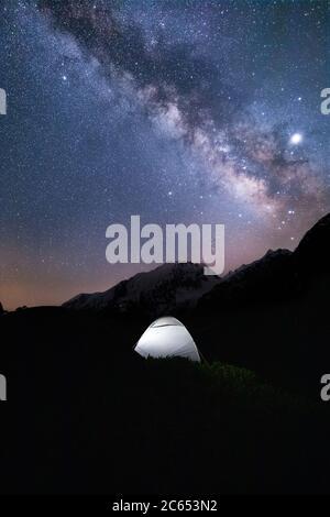 Die glänzende Milchstraße mit einem Zelt im Vordergrund, die spät in der Nacht auf einer Expedition im indischen himalaya festgehalten wurde Stockfoto