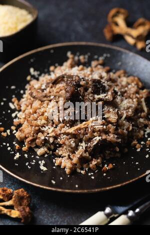 Gekochter Buchweizen mit getrockneten Pilzen auf einem Teller mit Parmesan bestreut. Vegetarische Gerichte. Russische, ukrainische Küche. Stockfoto