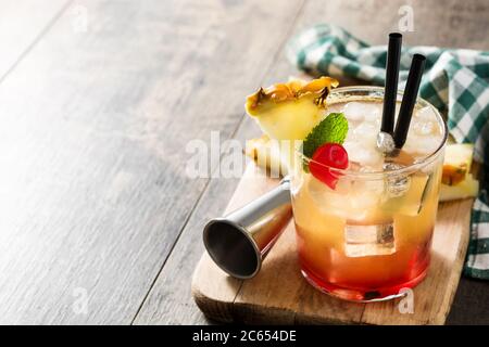 Kalter Mai Tai Cocktail mit Ananas und Kirsche auf Holztisch Stockfoto