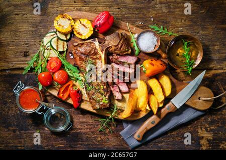 Rindersteak mit gegrilltem Gemüse und Gewürzen auf Servierbrett Stockfoto