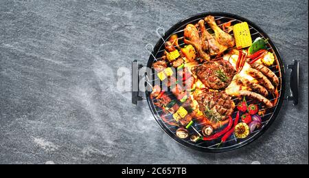 Draufsicht auf verschiedene leckere gegrilltes Fleisch mit Gemüse auf Grill mit Rauch und Flammen auf rustikalen Stein Hintergrund Stockfoto