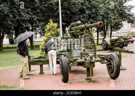 Witebsk, Weißrussland - 1. Juli 2018: Zwei männliche Touristen sehen die Ausstellung der sowjetischen Militärausrüstung des Zweiten Weltkriegs auf dem Siegesplatz auf dem regnerischen Sommer Stockfoto