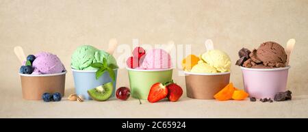 Verschiedene bunte Eiscreme-Sorten mit Früchten in Pappbechern Stockfoto