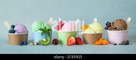 Verschiedene bunte Eiscreme-Sorten mit Früchten in Pappbechern Stockfoto