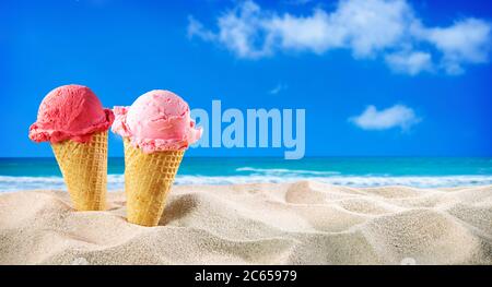Eiszapfen und Muscheln im Sand am Strand mit Meereslandschaft Stockfoto