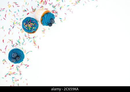 Muffins mit Heidelbeere und farbigen süßen streuen isoliert auf weißem Hintergrund. Flach liegend, Draufsicht Stockfoto