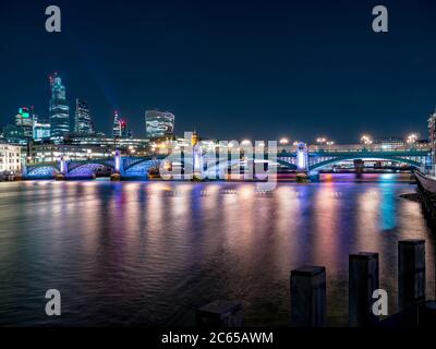 Nächtliche Panoramaaussicht auf die Themse mit Southwark Brücke und Finanzviertel im Hintergrund. Stadtbild von London, Großbritannien Stockfoto