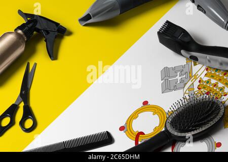 Vatikanstadt Flagge mit Haarschneidemassen. Kämme, Scheren und Friseurwerkzeuge in einem Schönheitssalon Desktop auf einem nationalen Holzhintergrund. Stockfoto