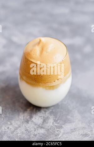 Iced Dalgona Coffee trendy flauschig cremig Schlagsahne Latte Espresso mit Schaum in transparentem Glas auf Marmor Hintergrund. Trendige Getränke Stadt Sperre und s Stockfoto