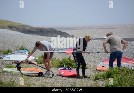 Wassersport in Barry an der Südwalesküste. Menschen genießen die Brandung an einem stürmischen Tag starten auf dem Kiesstrand in Cold Knap und reiten die Wellen. Stockfoto