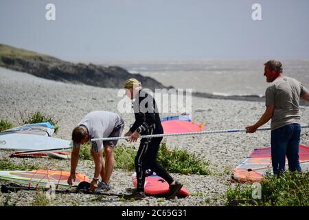 Wassersport in Barry an der Südwalesküste. Menschen genießen die Brandung an einem stürmischen Tag starten auf dem Kiesstrand in Cold Knap und reiten die Wellen. Stockfoto