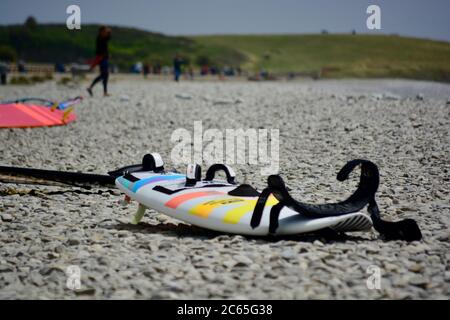 Wassersport in Barry an der Südwalesküste. Menschen genießen die Brandung an einem stürmischen Tag starten auf dem Kiesstrand in Cold Knap und reiten die Wellen. Stockfoto