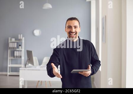 Handshake-Angebot. Ein Geschäftsmann bietet einen Handschlag, während er in einem Büro steht. Stockfoto