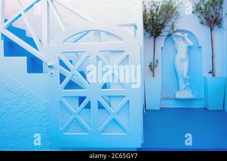 Ein romantischer versteckter Ort mit blauer Atmosphäre in Fira, Santorini, mit einer Statue im Hintergrund Stockfoto