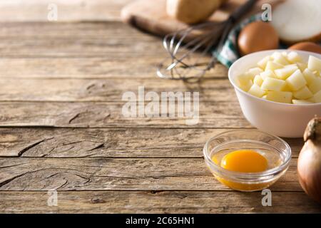 Spanische Omelette Tortilla Zutat: Eier, Kartoffeln und Zwiebeln auf Holztisch Stockfoto