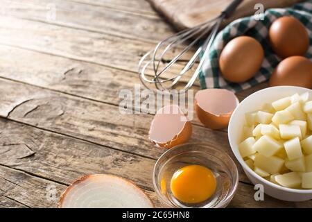 Spanische Omelette Tortilla Zutat: Eier, Kartoffeln und Zwiebeln auf Holztisch Stockfoto