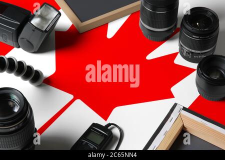 Kanada Nationalflagge mit Draufsicht auf persönliche Ausrüstung und Werkzeuge des Fotografen auf weißem Holztisch, Kopierraum. Stockfoto