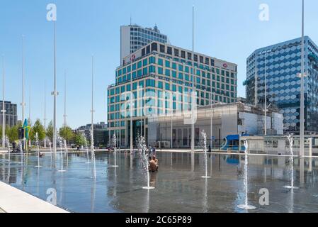 Menschen, die sich in den Wasserfontänen im Wasserspiegel am Centenary Square, Birmingham, Großbritannien, abkühlen Stockfoto