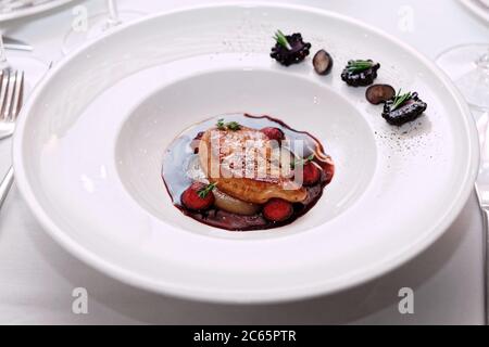 Gebratene Foie Gras mit Portosauce auf Restauranttisch, getönt Stockfoto