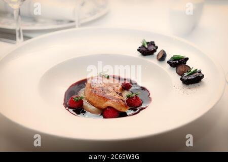 Foie Gras mit Portosauce auf weißem Teller, Haute Cuisine, Nahaufnahme, getönt Stockfoto