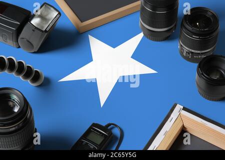 Somalia Nationalflagge mit Draufsicht auf persönliche Ausrüstung und Werkzeuge des Fotografen auf weißem Holztisch, Kopierraum. Stockfoto