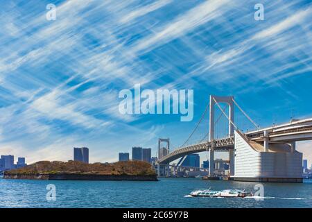 tokio, japan - april 04 2020: Wasserbus fährt auf der Tokyo Bay vor der zweischichtigen Regenbogenbrücke und der Bucht von Odaiba mit Cirru Stockfoto