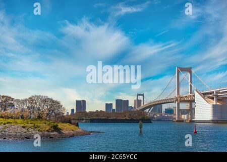 tokio, japan - april 04 2020: Vogelinsel Odaiba Bay vor der zweischichtigen Regenbogenbrücke im Hafen von Tokio mit Cirrus Clou Stockfoto