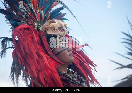 Nahaufnahme unbekannte Maya-Frau mit traditioneller Tracht mit Federkopfschmuck und einem Schädel auf ihrer Stirn - sie tanzt in einem Stammestanz. Stockfoto