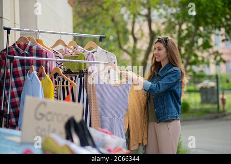 Angenehme gut aussehende Frau auf der Suche nach einem neuen Kleid Stockfoto