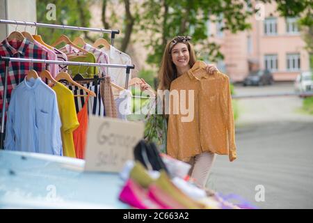 Positive nette Frau hält eine schöne Bluse Stockfoto