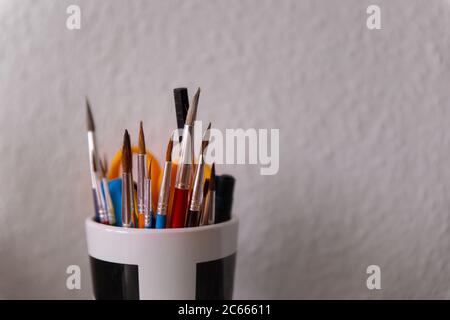 Kunstbedarf mit einem Bündel von Pinsel in einer Tasse Stockfoto