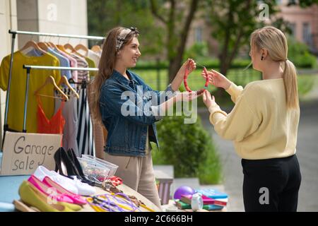 Schöne blonde Frau, die die Halskette vom Verkäufer Stockfoto