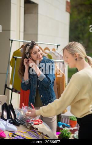 Angenehme nette Frau, die einen Ohrring aufsetzt Stockfoto