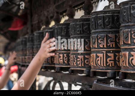 Gläubige drehen die Gebetsräder in Swayambhunath bei Kathmandu in Nepal Stockfoto