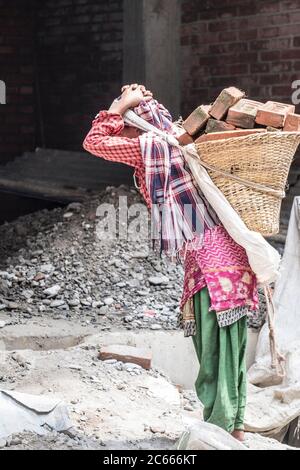 Baustelle mit Frau, die Steine trägt in Swayambhunath bei Kathmandu in Nepal Stockfoto