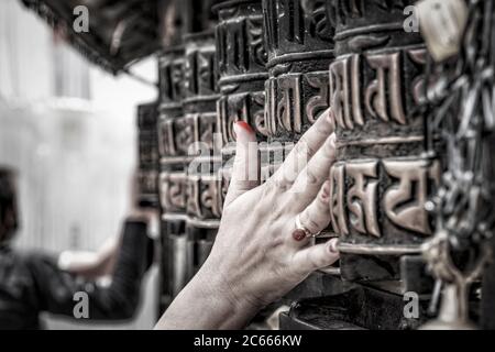 Gläubige drehen die Gebetsräder im Swayambhunath Tempel in der Nähe von Kathmandu in Nepal Stockfoto