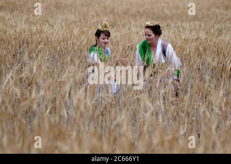 07. Juli 2020, Sachsen, Großweitzschen: Elisabeth Dreher (l), sächsische Erntekönigin, und Wibke Frotscher, sächsische Ernteprinzessin, stehen auf einem Gerstenfeld. Der Staatliche Bauernverband gab Auskunft über die Ernteprognose für 2020, wobei Frost im Mai und Dürre zu niedrigeren Erträgen führten. Foto: Sebastian Willnow/dpa-Zentralbild/dpa Stockfoto