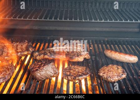 Ein Grill voller verschiedener Steaks, einschließlich Ribeye, T-Bone, Porterhouse, New York Strip, Kansas City Strip, Filet Mignon, plus Hamburger und Bratens Witz Stockfoto