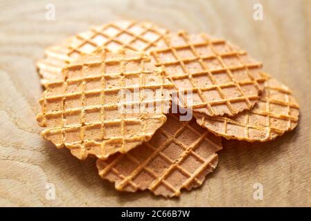 Dünne köstliche runde Waffeln auf einem Holzhintergrund, Nahaufnahme Stockfoto