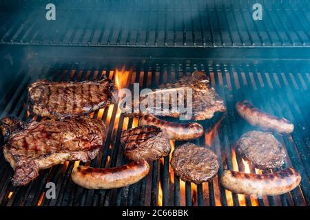 Ein Grill voller verschiedener Steaks, einschließlich Ribeye, T-Bone, Porterhouse, New York Strip, Kansas City Strip, Filet Mignon, plus Hamburger und Bratens Witz Stockfoto